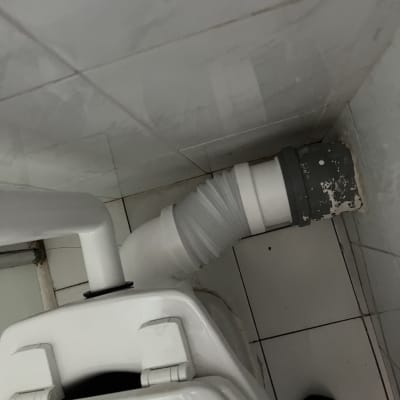 צינור פלסטיק מחובר לאסלה בחדר אמבטיה