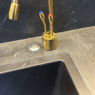 ברז זהב על רקע שיש כהה במטבח