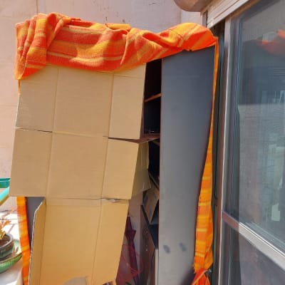 ארגזים וארון מכוסים בשמיכה כתומה במעבר