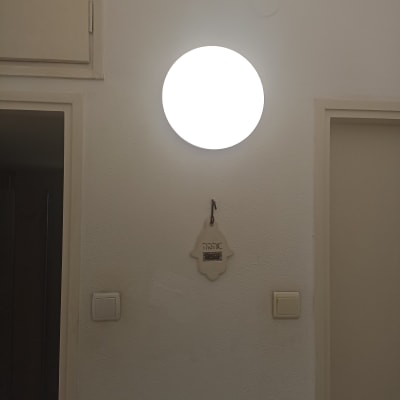 מנורה עגולה על קיר עם מתגי חשמל