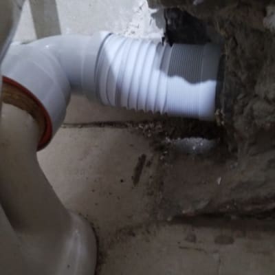 צינור פלסטיק לבן מחובר לקיר בטון