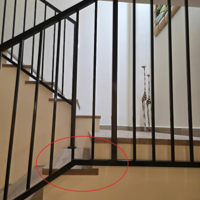 מעקה מתכת שחור מעוצב המותקן בגרם מדרגות פנימי