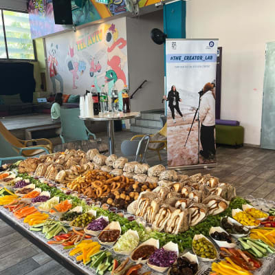 שולחן קייטרינג עם ירקות, לחמים ומטבלים שונים.