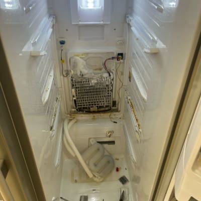 תא מקרר פתוח עם כלים וחלקים פנימיים חשופים