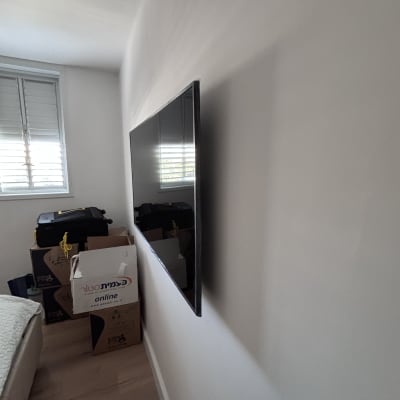 טלוויזיה מותקנת על קיר עם קופסאות ברקע