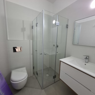 מקלחון זכוכית עם דלתות מתכת בחדר אמבטיה מודרני