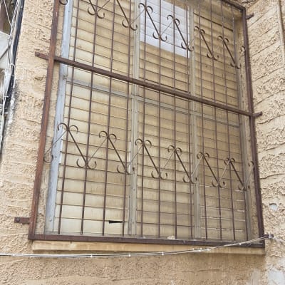 תריסים ישנים עם סורגים על קיר חיצוני