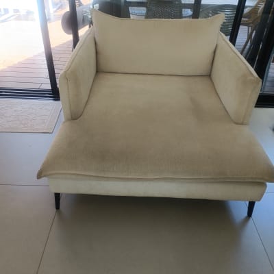 ספה בהירה ליד חלון זכוכית עם נוף חיצוני