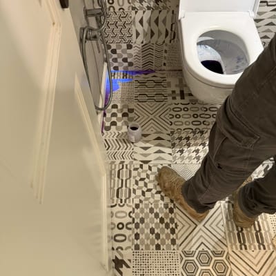 אדם עם נעליים ליד אסלה וכלי עבודה