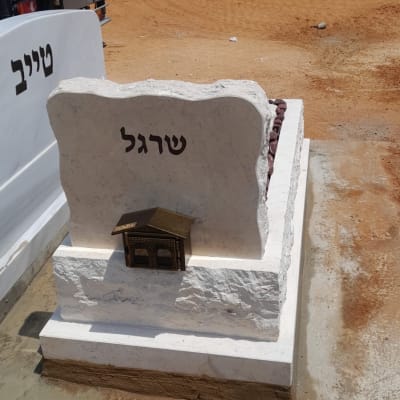 מצבה עם שם שרגל על רקע שטח פתוח