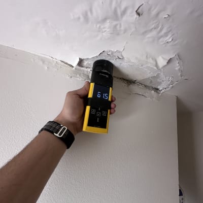 מד לחות על תקרה עם סימני רטיבות