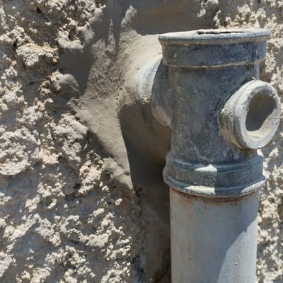 צינור מתכת מחובר לקיר בטון