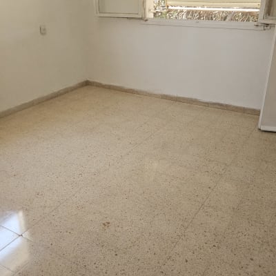 חדר ריק עם רצפת אריחים ודלת פתוחה