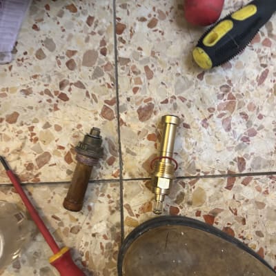 כלים וחלקים על רצפה, כולל מברגים וחלקי צנרת