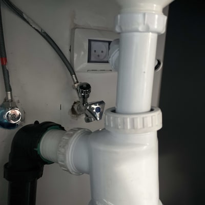 צנרת מתחת לכיור עם חיבורים וברזים