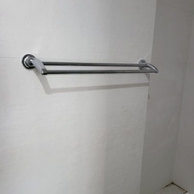 מוט מגבת מתכת מותקן על קיר לבן