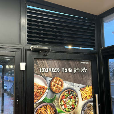 תריסי אלומיניום שחורים מעל דלת זכוכית