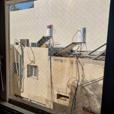 רשת יונים מותקנת על חלון למניעת כניסת יונים