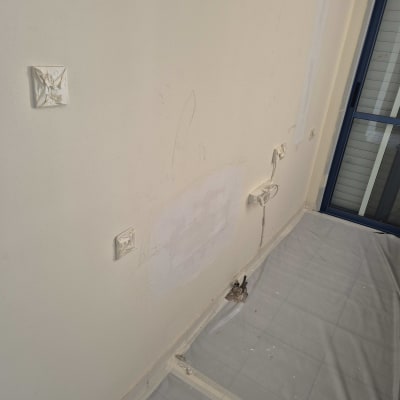 קיר עם תיקוני צבע, יריעת ניילון על הרצפה