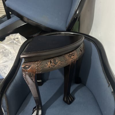 כיסאות מרופדים בכחול עם שולחן קטן מעץ.