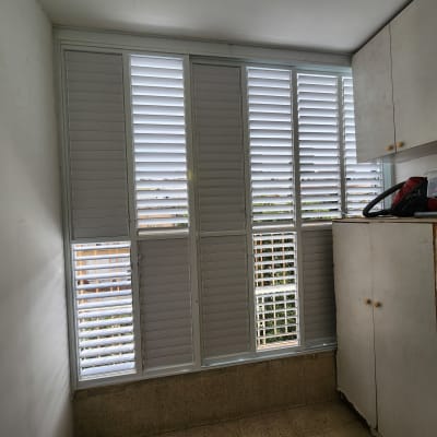 תריסי אלומיניום לבנים בחלון גדול