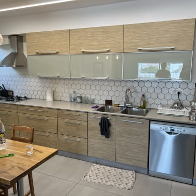 מטבח מודרני עם ארונות עץ ומשטח עבודה