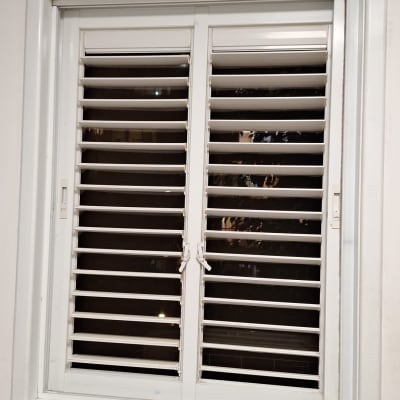 חלון עם תריסים לבנים נקיים