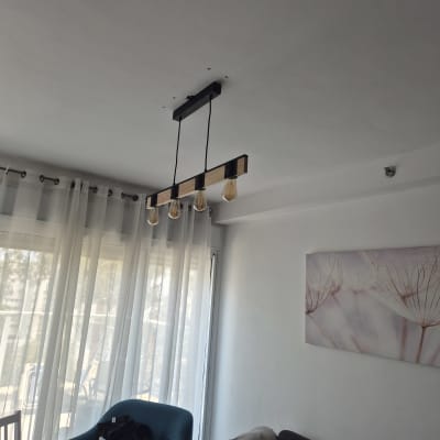 מנורת תקרה עם ארבע נורות תלויה בחדר מגורים.