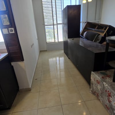 קירות צבועים בלבן בדירה מרוהטת עם ריהוט שמרוכז במרכז החדר