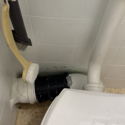 תיקון וחיבור צנרת ביוב בחלק האחורי של אסלה
