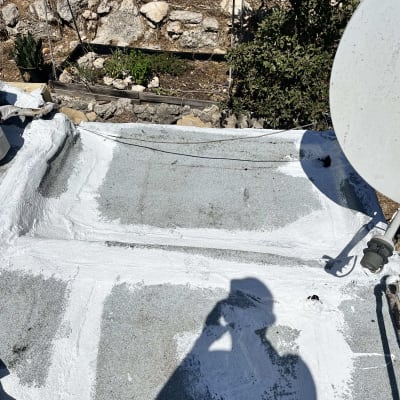 איטום גג עם חומר לבן וצל של אדם