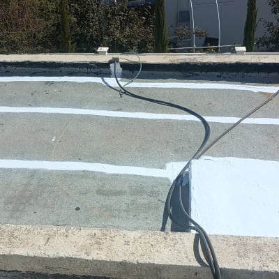 גג עם ציפוי איטום לבן וחוטים