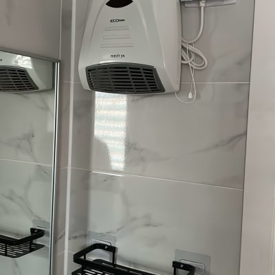 מאוורר חשמלי מותקן על קיר בחדר אמבטיה