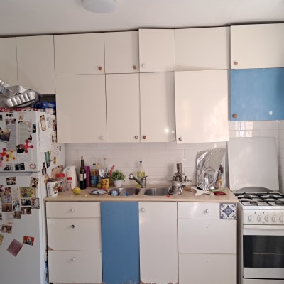 מטבח עם ארונות לבנים ותנור גז