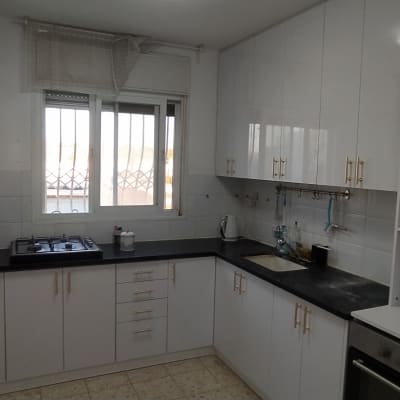 מטבח עם ארונות לבנים, תנור ומיקרוגל