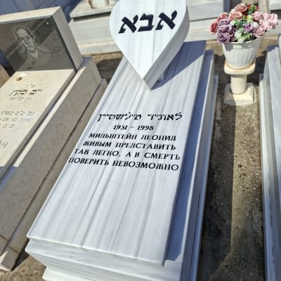 מצבת שיש מעוצבת עם אלמנט בצורת לב וכיתוב מושחר