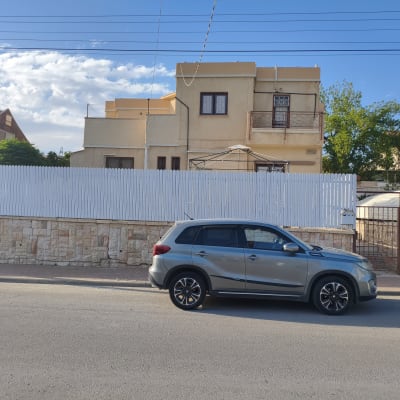 רכב כסוף חונה מול גדר לבנה