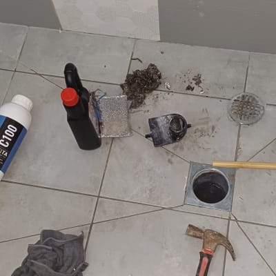 כלים וחומרים לתיקון צנרת על רצפת חדר אמבטיה