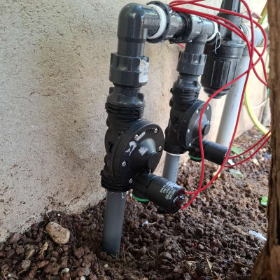 מערכת השקיה עם צינורות ושסתומים בגינה