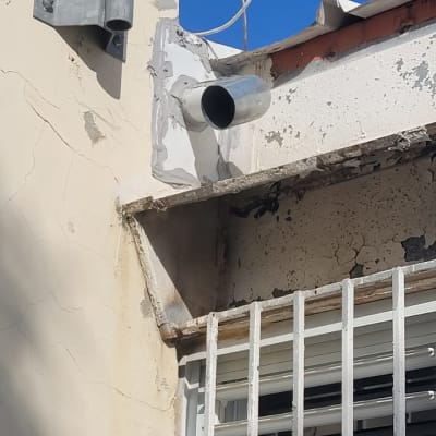 צינור מתכת מותקן על קיר ליד גג