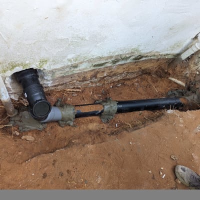 צינור ביוב שחור עם חיבורים בקיר