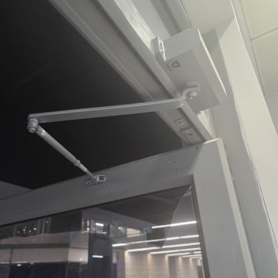 מנגנון סגירה אוטומטי לדלת זכוכית עם זרוע מתכתית