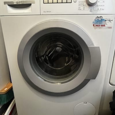 מכונת כביסה בוש עם מדבקה וטלפון