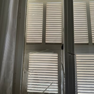 חלון עם זכוכית שבורה ותריסים סגורים