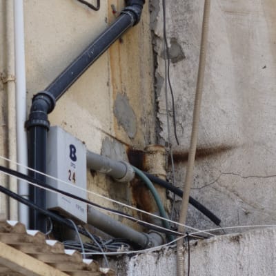 צינורות וחיבורים על קיר חיצוני עם סימני חלודה