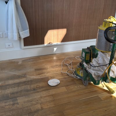 מכונת ליטוש על רצפת עץ עם כבלים וכלים נוספים