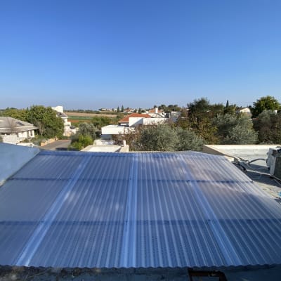 גג עם לוחות פלסטיק גלי ומזגן מותקן