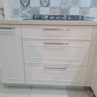 ארונות מטבח לבנים עם ידיות מתכת וכיריים עליונים