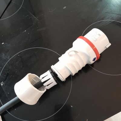 תקע חשמלי לבן עם כבל שחור על משטח כהה