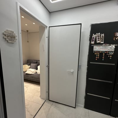 דלת לבנה פתוחה עם מסגרת שחורה בחדר מואר